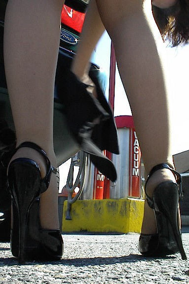 Close-up of legs wearing black high heels with a blurred background
