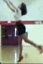 Person performing a high jump in an indoor sports facility with 'Williams' visible on the wall.