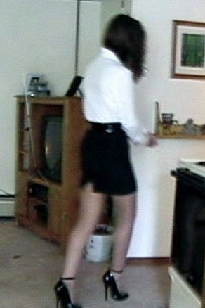 Person standing on a kitchen counter with a television and various items in the background