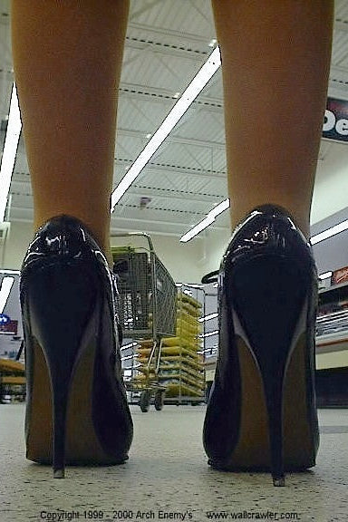 Randi Johnson wearing pantyhose and high heels standing in a store aisle.