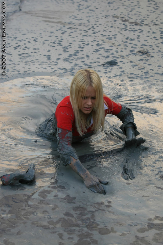 Person in red shirt and gloves playing in mud