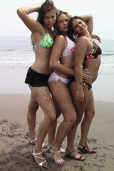Three women in swimsuits posing on a beach with a copyright notice at the top.