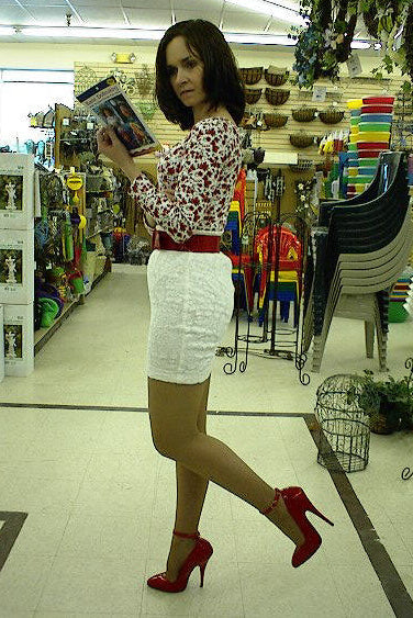 Woman in a store holding a product, with shelves and products in the background