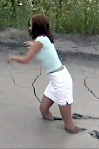 Woman walking in mud, quicksand with  grass in the background